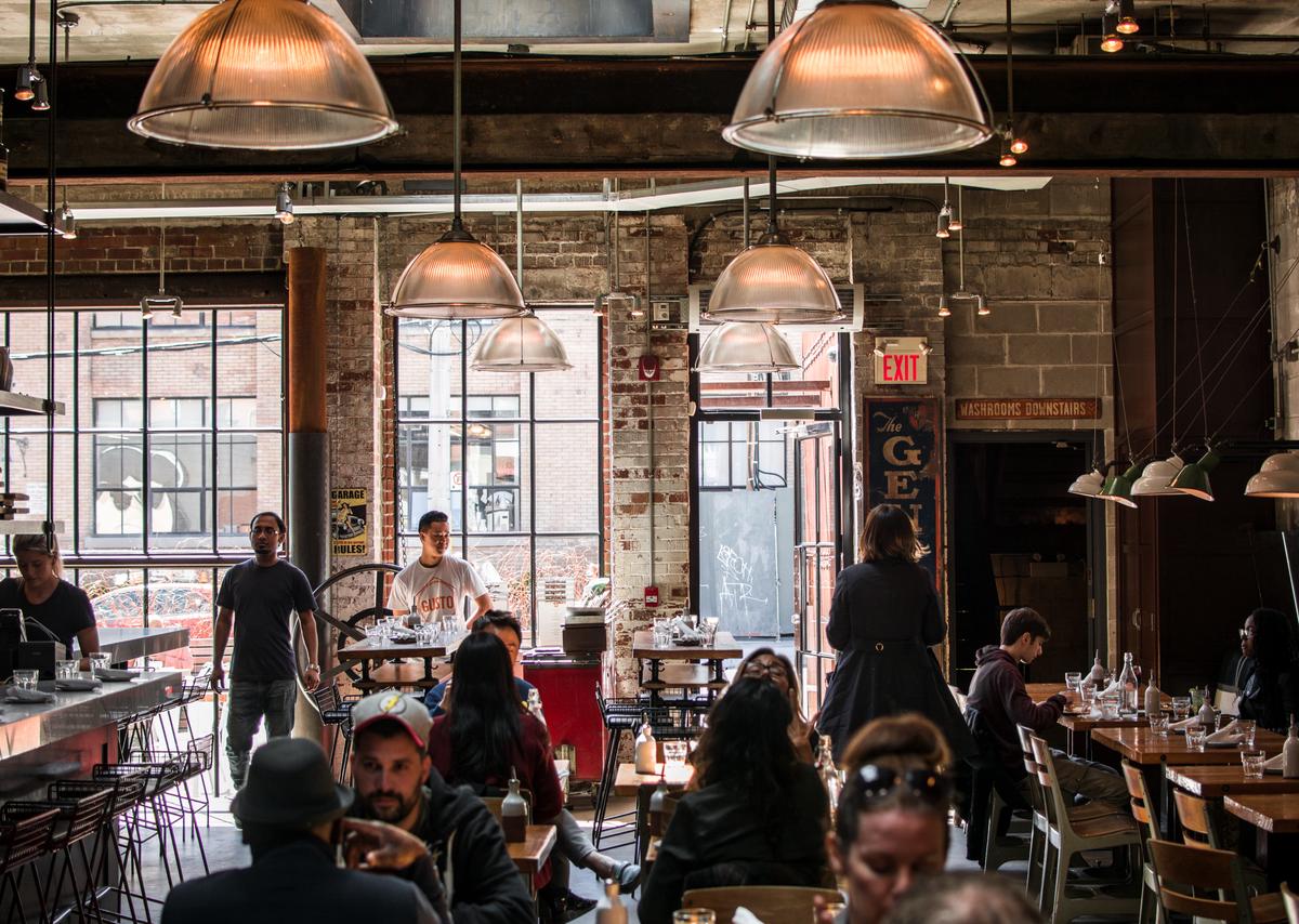 Image depicting people dining in a restaurant and a person cooking in a kitchen.