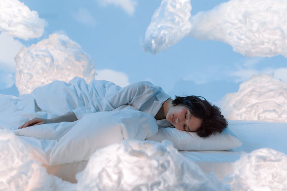 Illustration of a person sleeping, with a dream cloud above them, surrounded by stars.