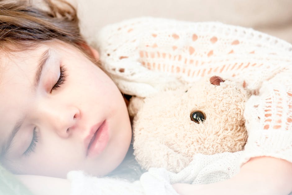 An image of a person sleeping and colorful dream bubbles surrounding them.