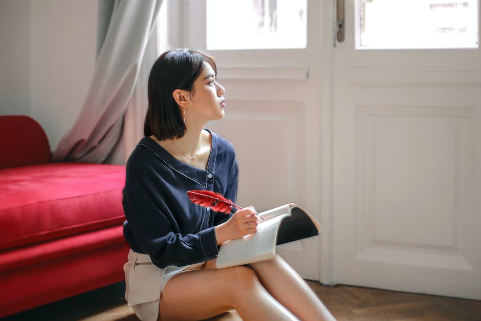 Image description: A person sitting on the edge of a bed, deep in thought.